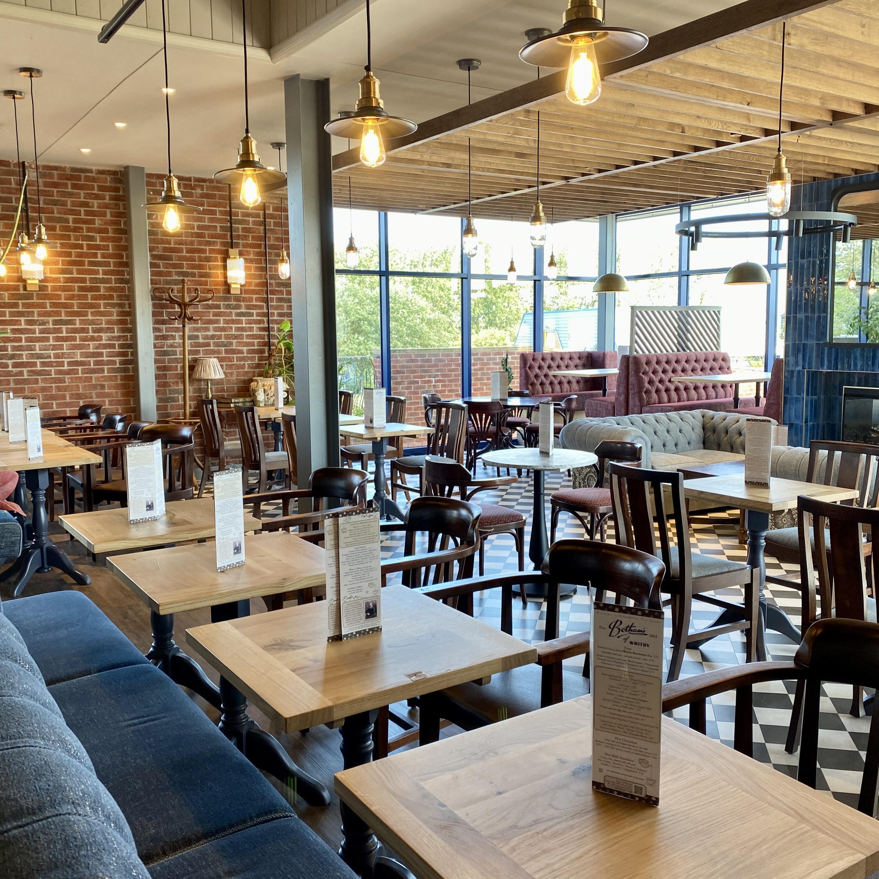 Image displays the interior of Botham's of Whitby's new Tea Room on Enterprise Way, including table, booth and relaxed seating, with exquisite interior design features.