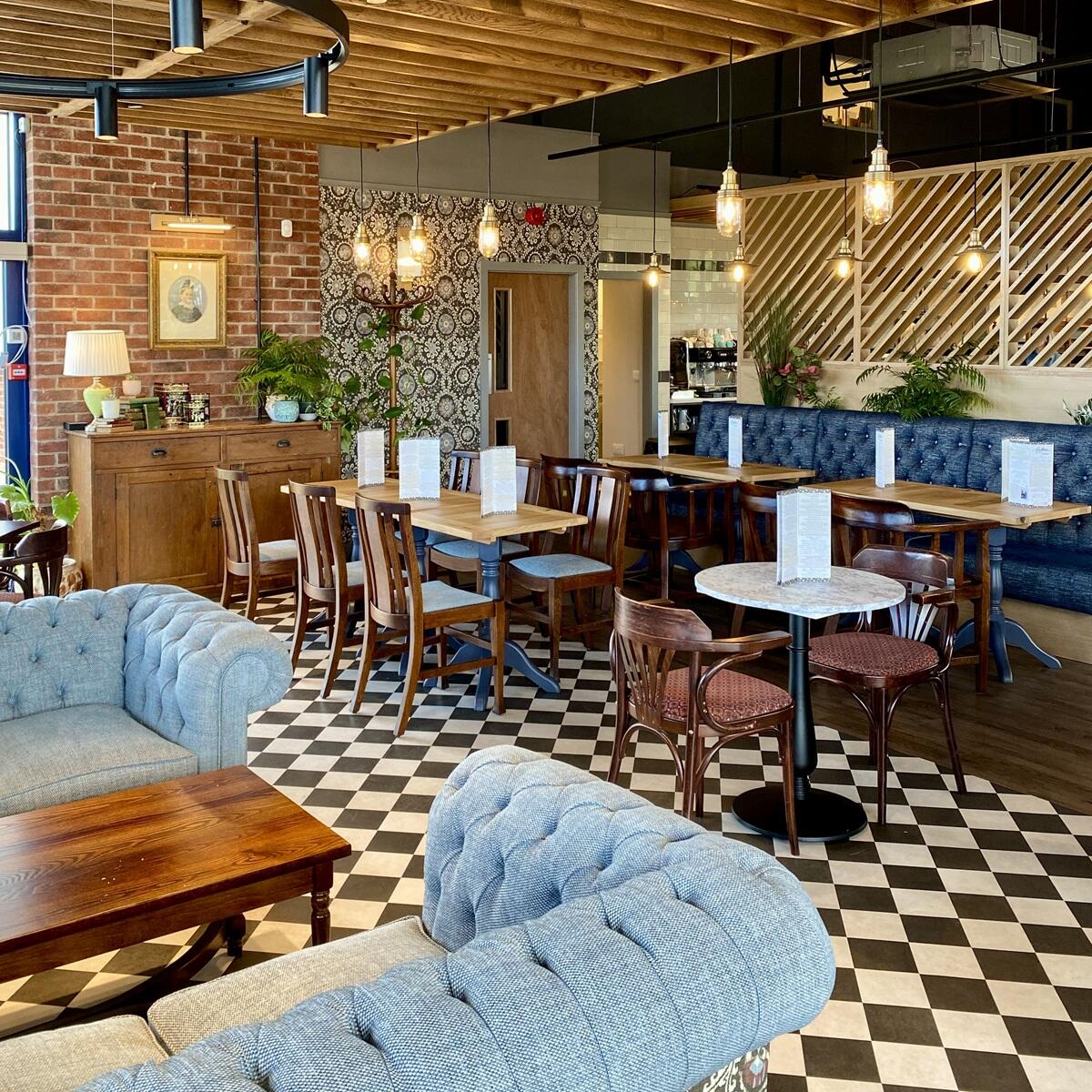Image displays the interior of Botham's of Whitby's new Tea Room on Enterprise Way, including table, booth and relaxed seating, with exquisite interior design features.