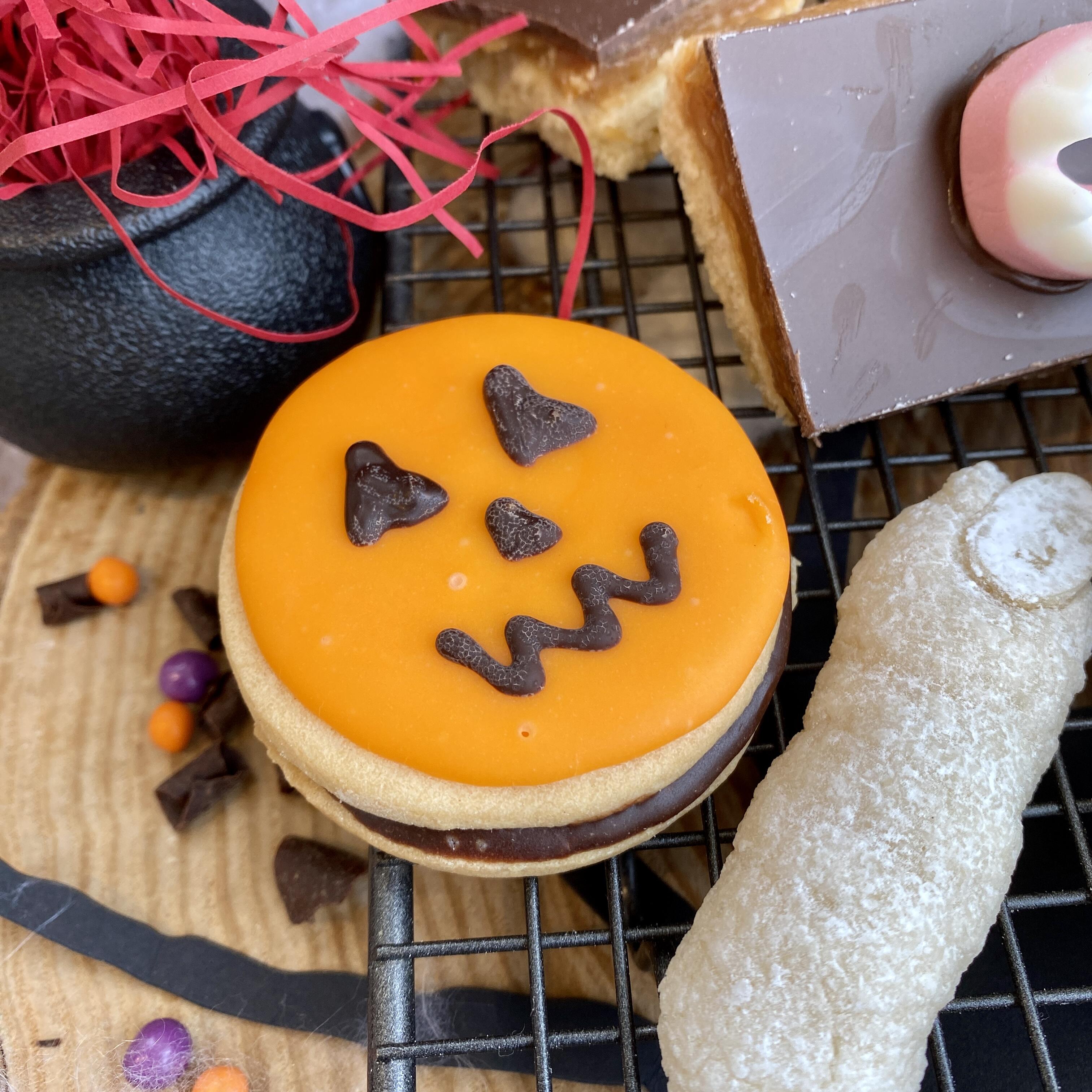 Botham's of Whitby Jack-O'-Lantern Button Moon which features two round vanilla biscuits sandwiched together with chocolate ganache, topped with an orange fondant circle with chocolate piped scary eyes and mouth! A spook-tacular Halloween cake from Botham's iconic Whitby bakery.
