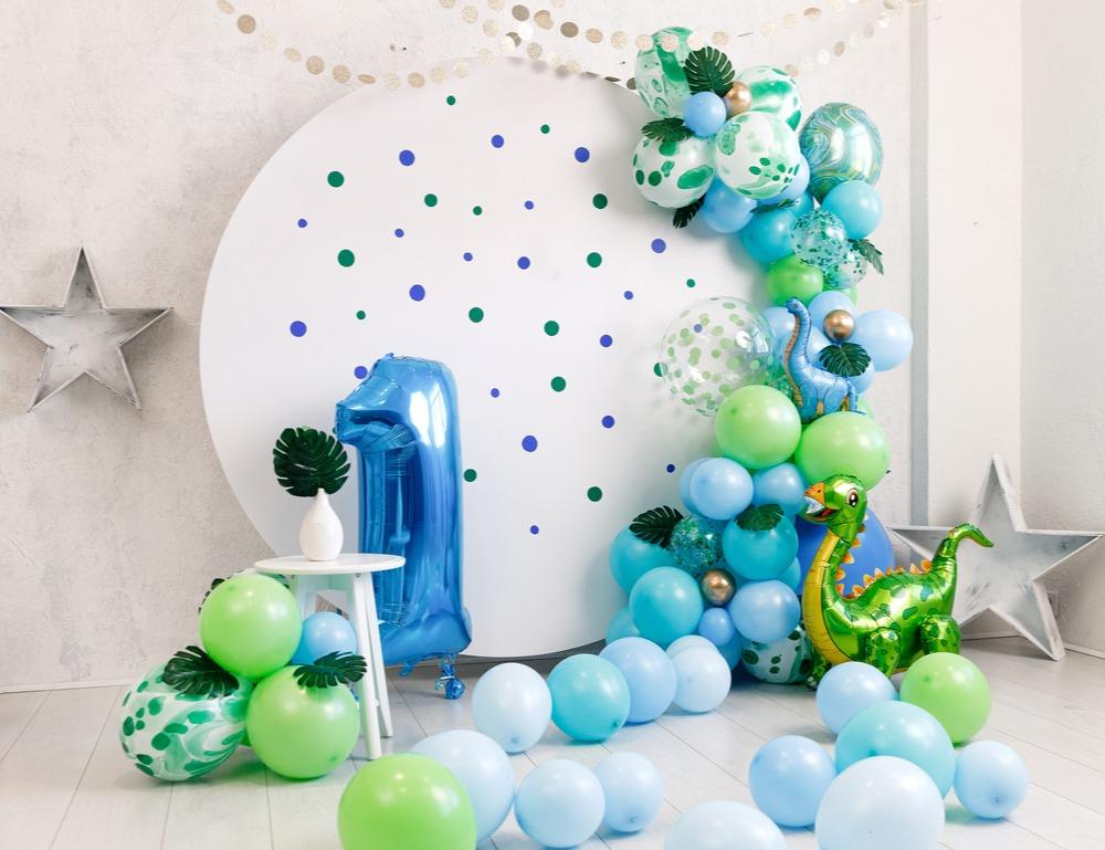 Green, blue and white balloons in an arch shape with 2 foil Dinosaur Balloons