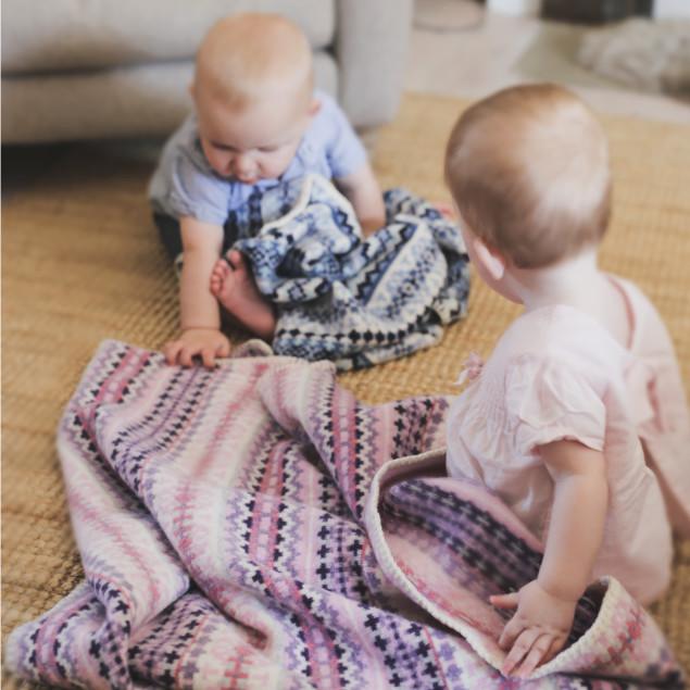 Twins playing with Fairisle lambswool baby blankets by Tuppence and Crumble