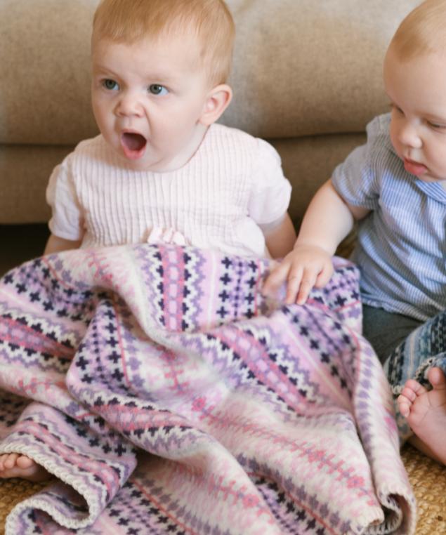 Girl yawning with Pink Fairisle baby blanket lambs wool blanket