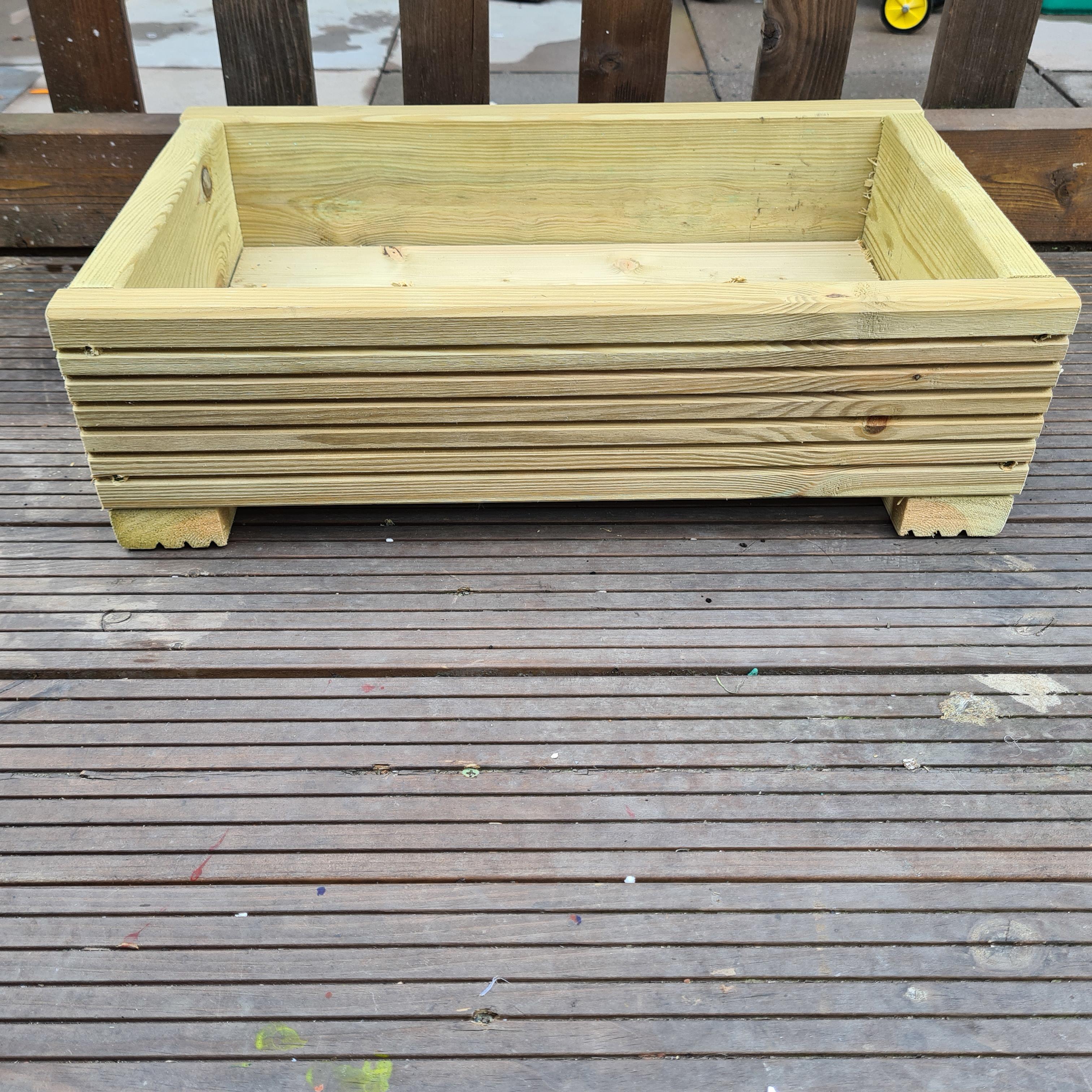 Decking planter on a decking base with a picket fence in the background