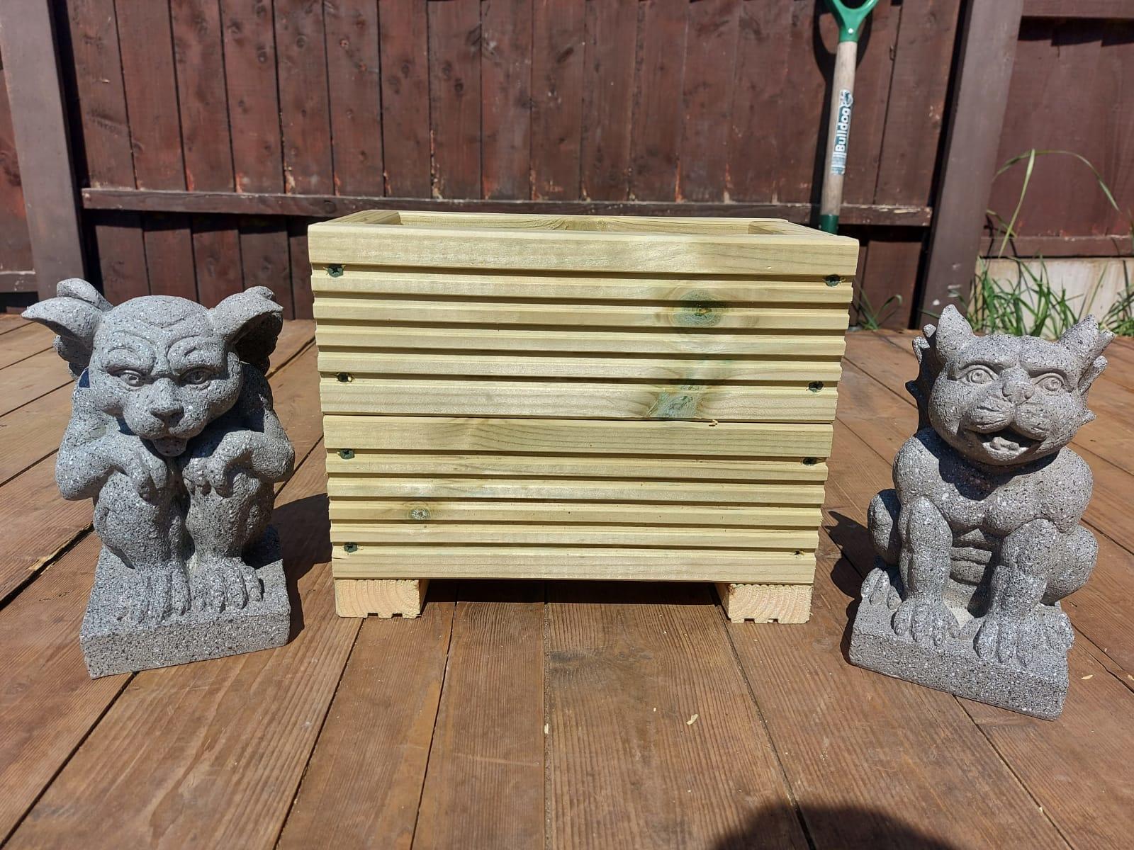 decking planter on wood deck base with statues each side of the planter