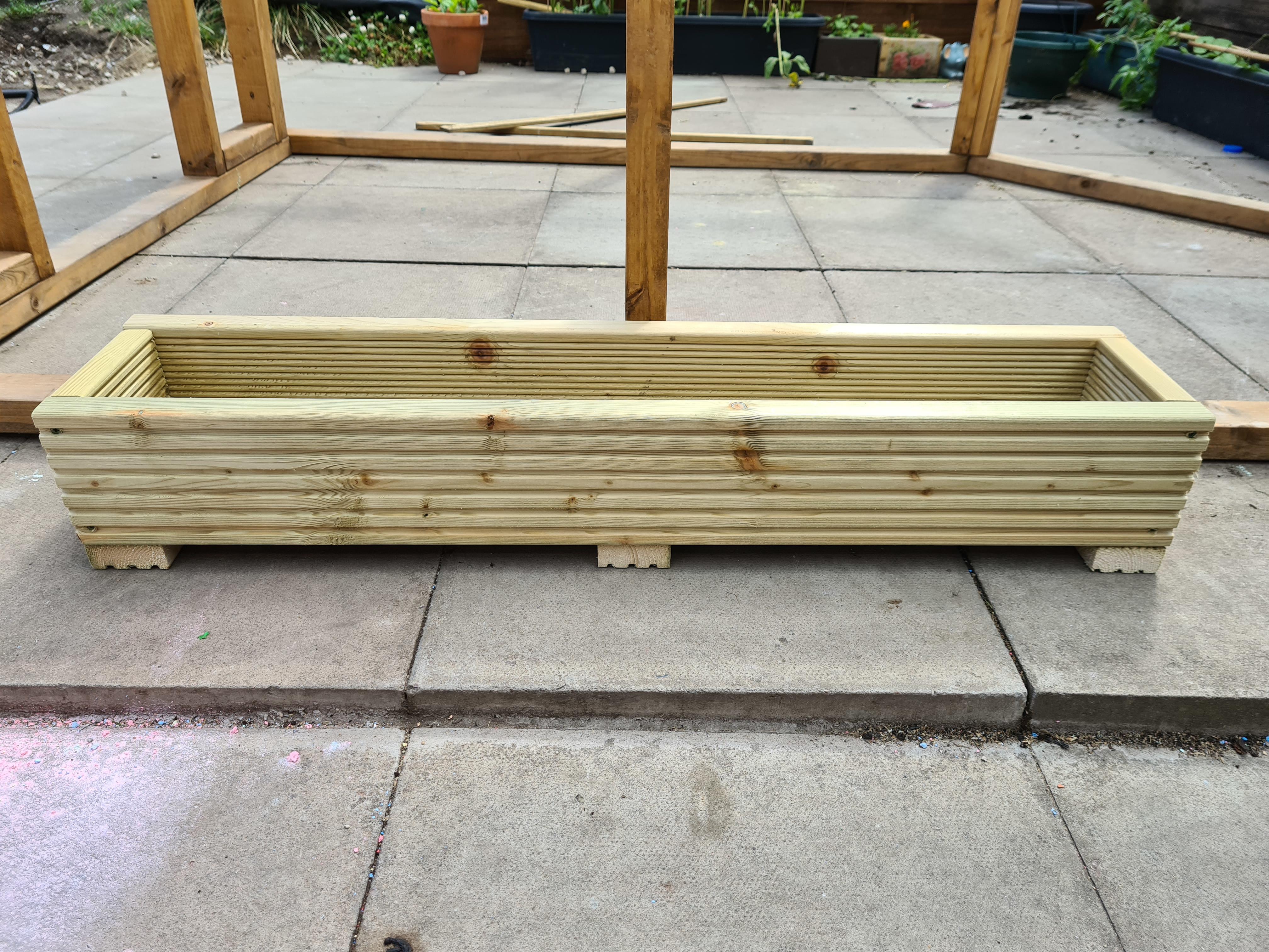 decking planter with wooden frame in background on a slap base