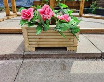 decking planter on slabs with artificial flowers