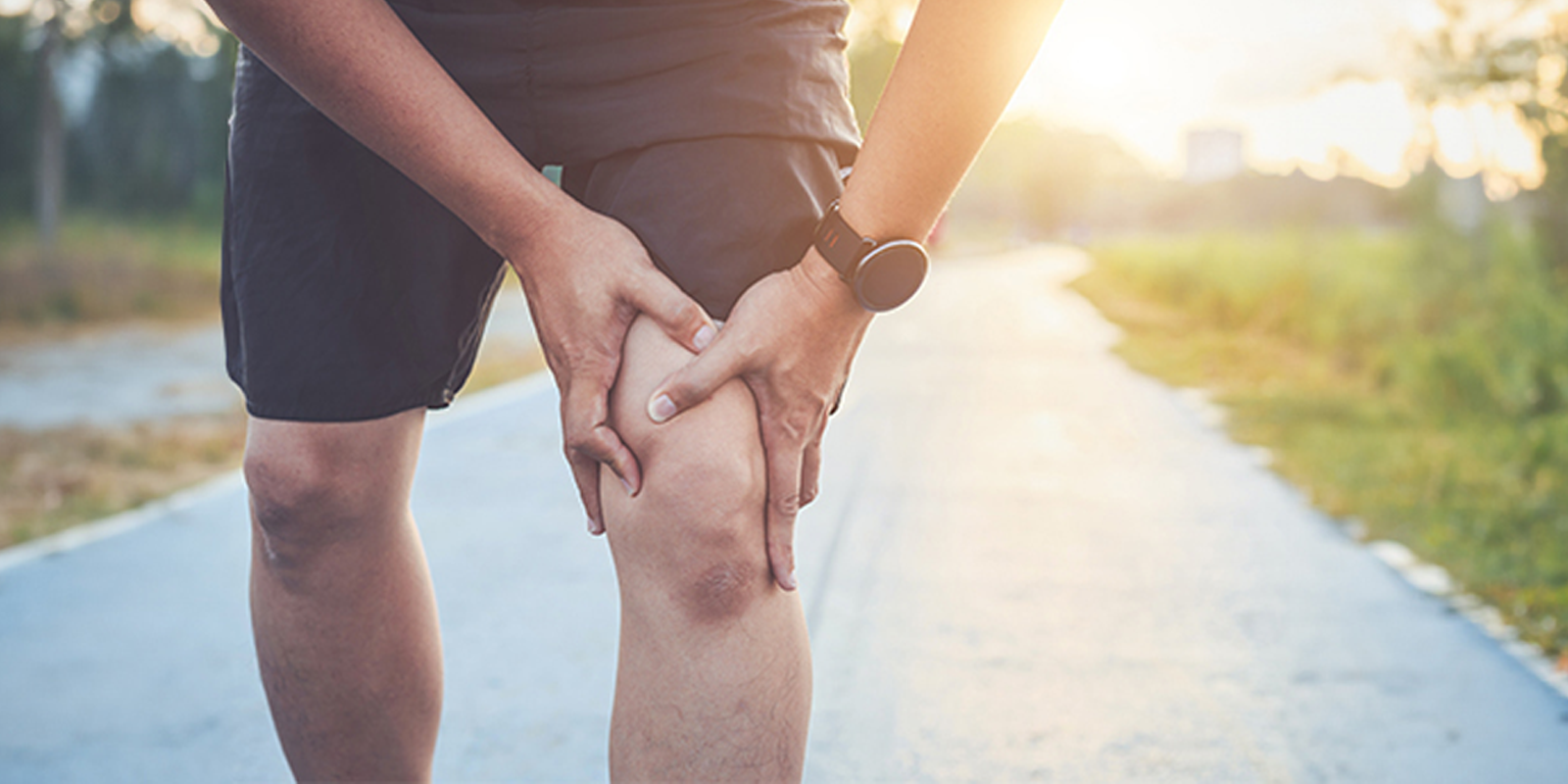 A runner holding his knee experiencing joint pain from running 