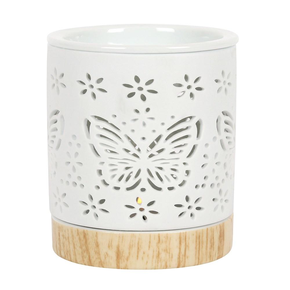 White Cylinder wax warmer with butterfly and flower shapes cut into it and a light wood look base