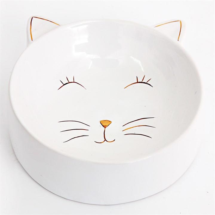 White ceramic bowl that has cat ears and gold embellishment face inside the bowl.