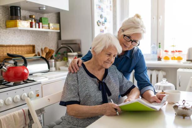 An image of a woman sitting at a table being helped with home planning of Lifemax products
