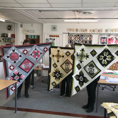 picture of students holding there projects in the studio
