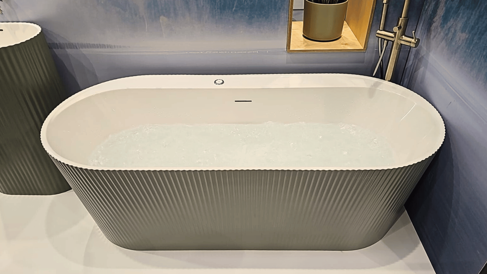 Whirlpool bath in a contemporary bathroom with warm neutral tiles