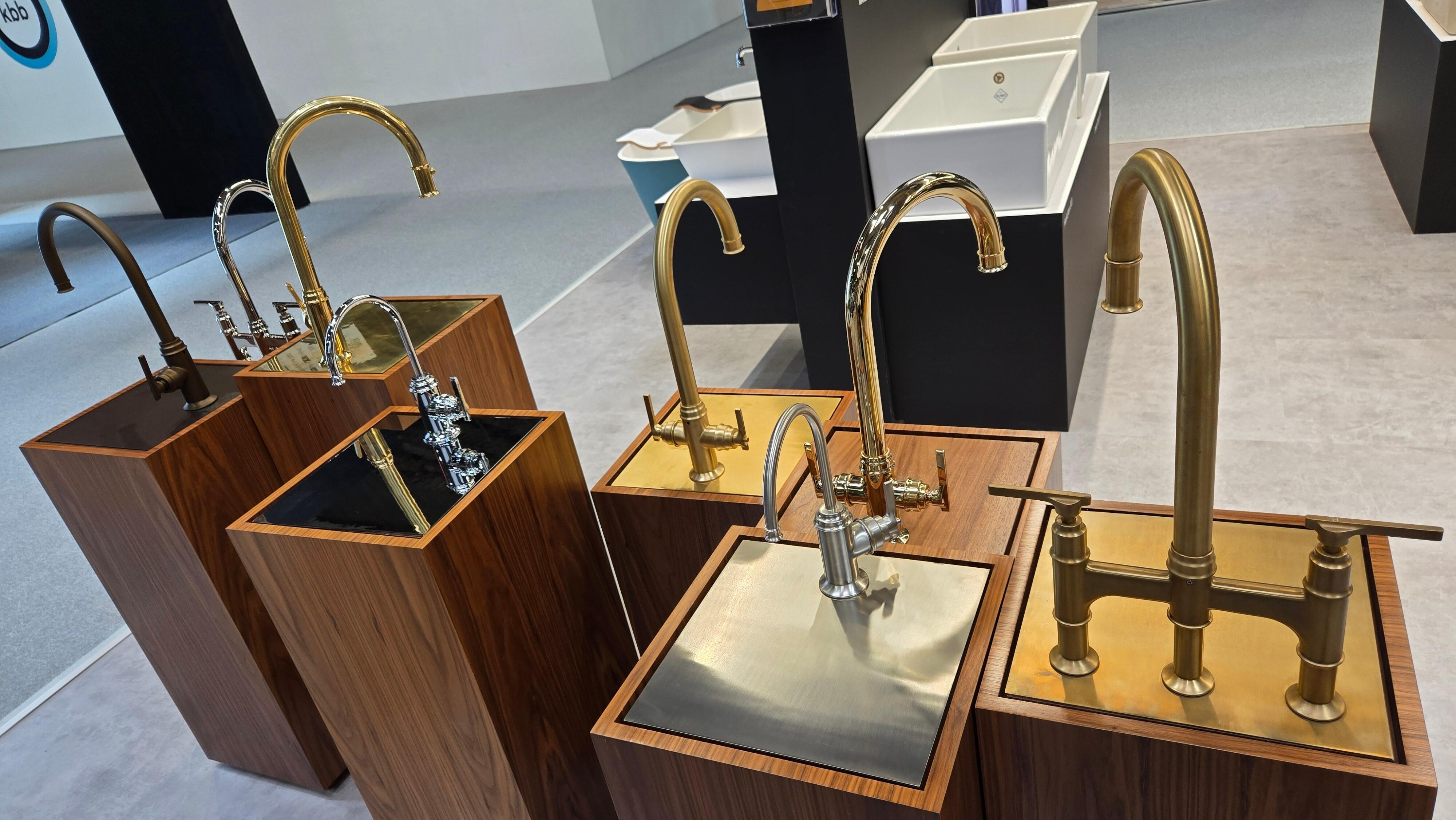 Brushed brass and brushed nickel bathroom taps in a warm-toned setting