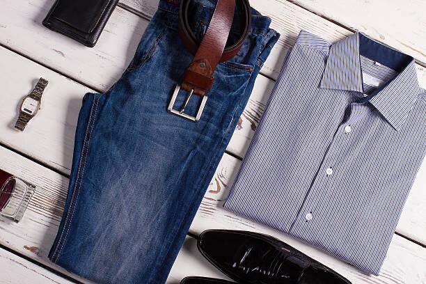 Men’s apparel including a folded shirt and shoes displayed on a white .