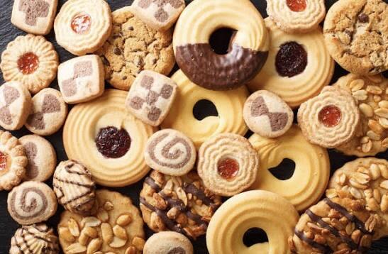 Assorted biscuits arranged together, featuring a variety of shapes, textures, and flavours including chocolate-coated, plain, and filled biscuits