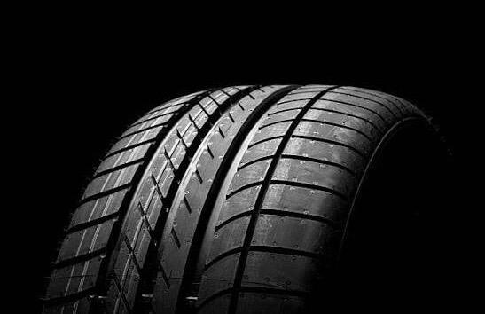 Tyre on black background, showing tread pattern and sidewall details
