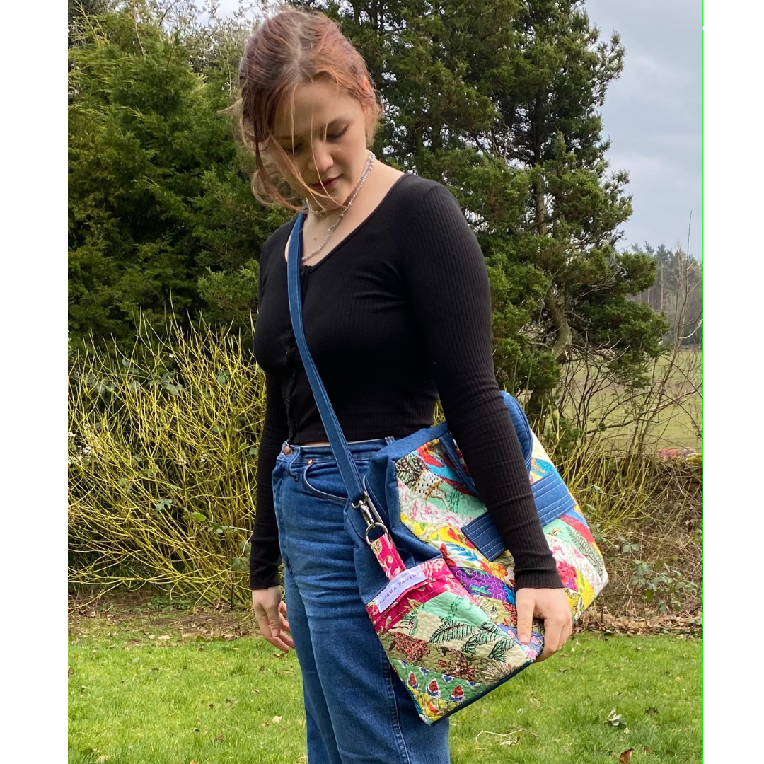 Girl using shoulder strap of  patchwork flightbag , wae