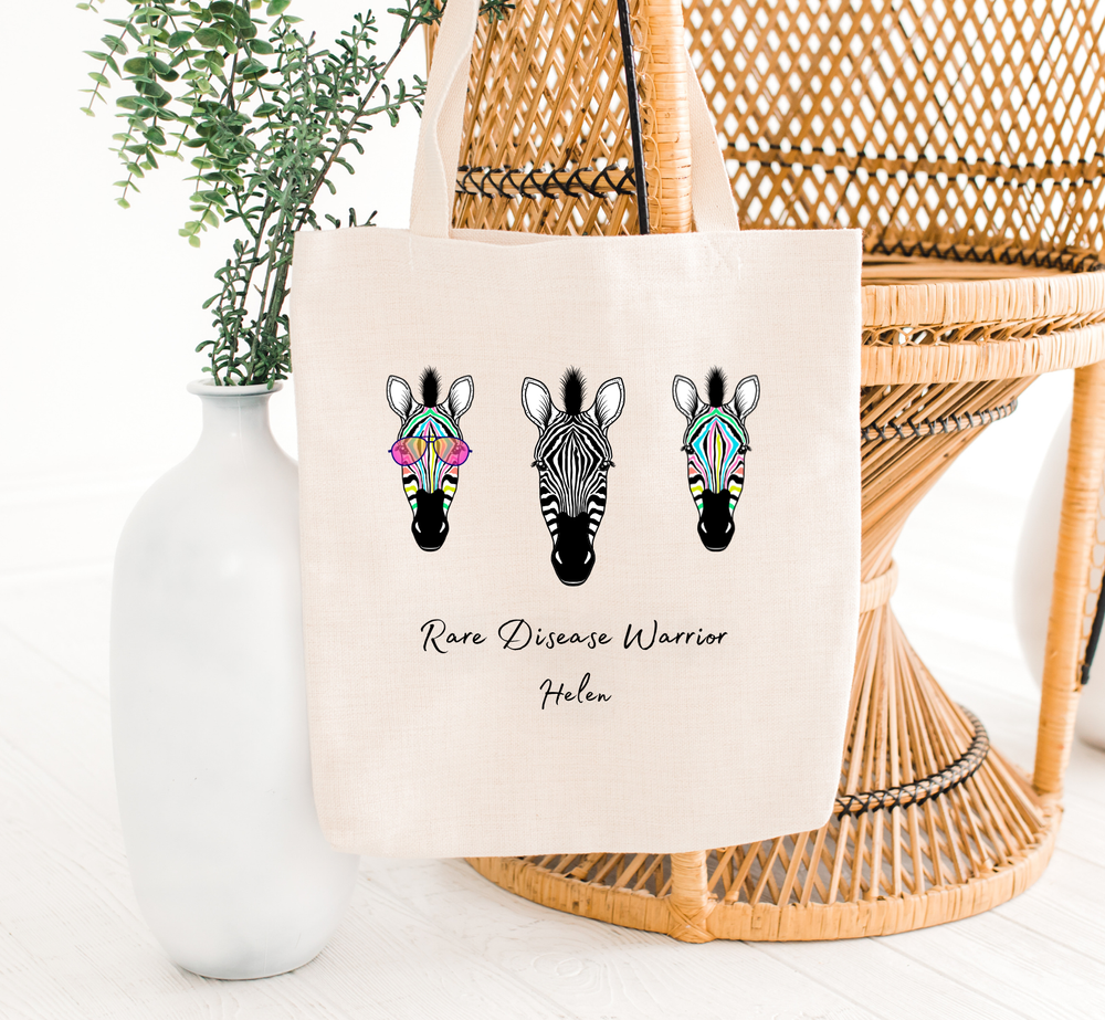 rare disease warrior tote bag hanging on a chair with zebras, the holistic hamper