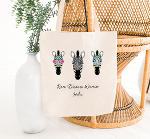 rare disease warrior tote bag hanging on a chair with zebras, the holistic hamper