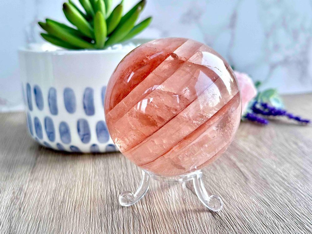 large fire quartz crystal sphere on a stand