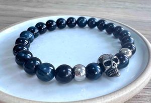 Blue tigers eye crystal mens bracelet in 8mm gemstone beads on a dish
