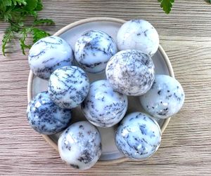 merlinite dendritic white opal crystal tumble stones on a dish