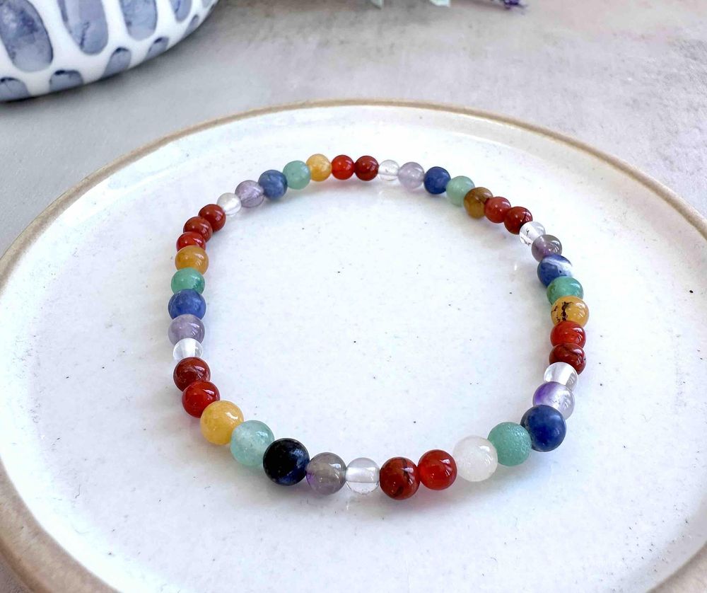 4mm round bead chakra crystal stretch bracelets in rainbow colours on a dish