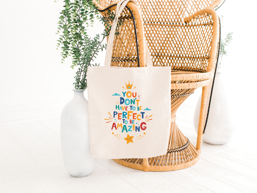 You don't have to be perfect to be amazing cotton tote bag, hanging on a chair