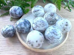 merlinite dendritic white opal crystal tumble stones on a dish