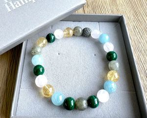 Scorpio zodiac crystal bracelet with lava diffuser bead in pinks, yellows and greens in a box