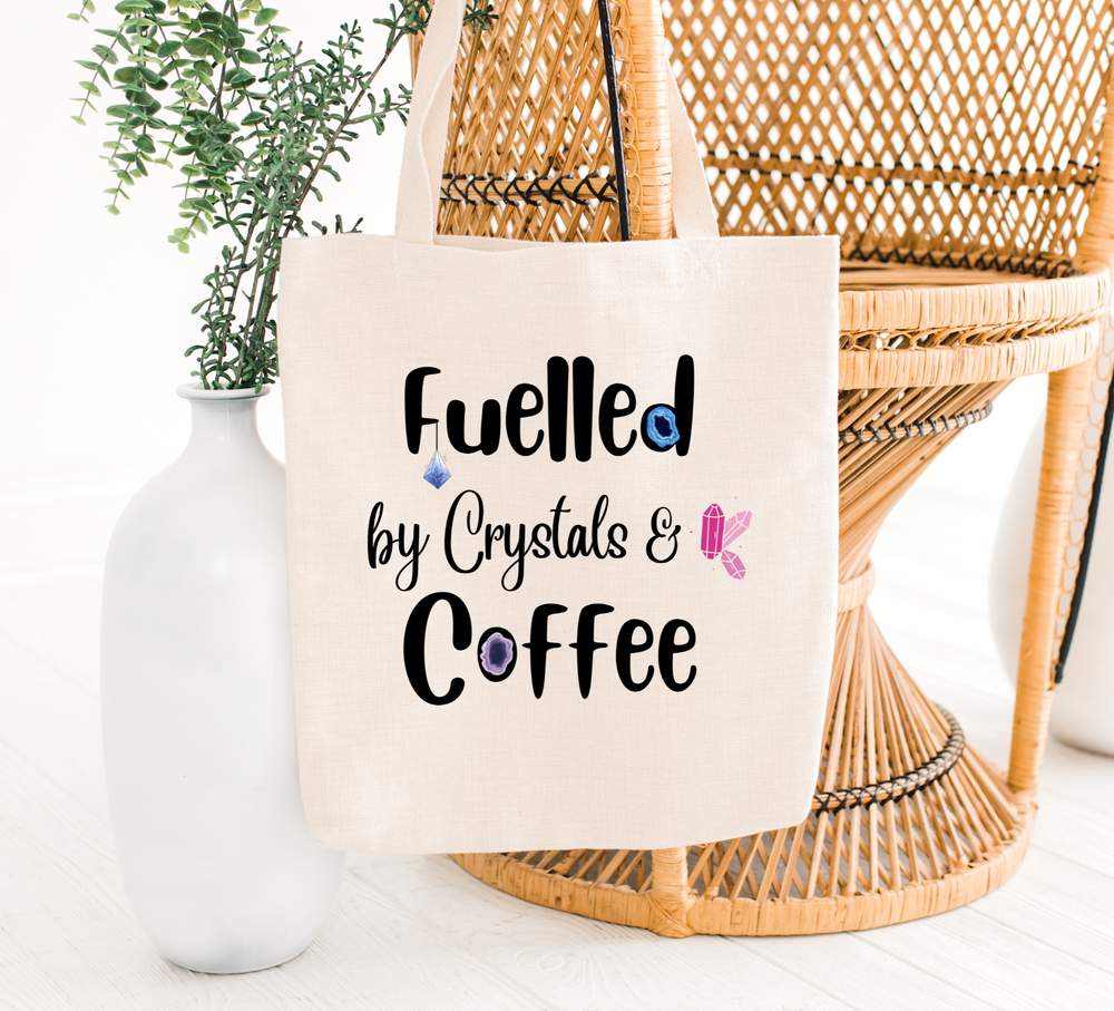 fuelled by crystals tote bag hanging on a chair