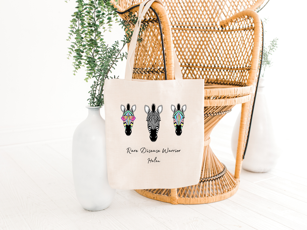 rare disease warrior tote bag hanging on a chair with zebras, the holistic hamper