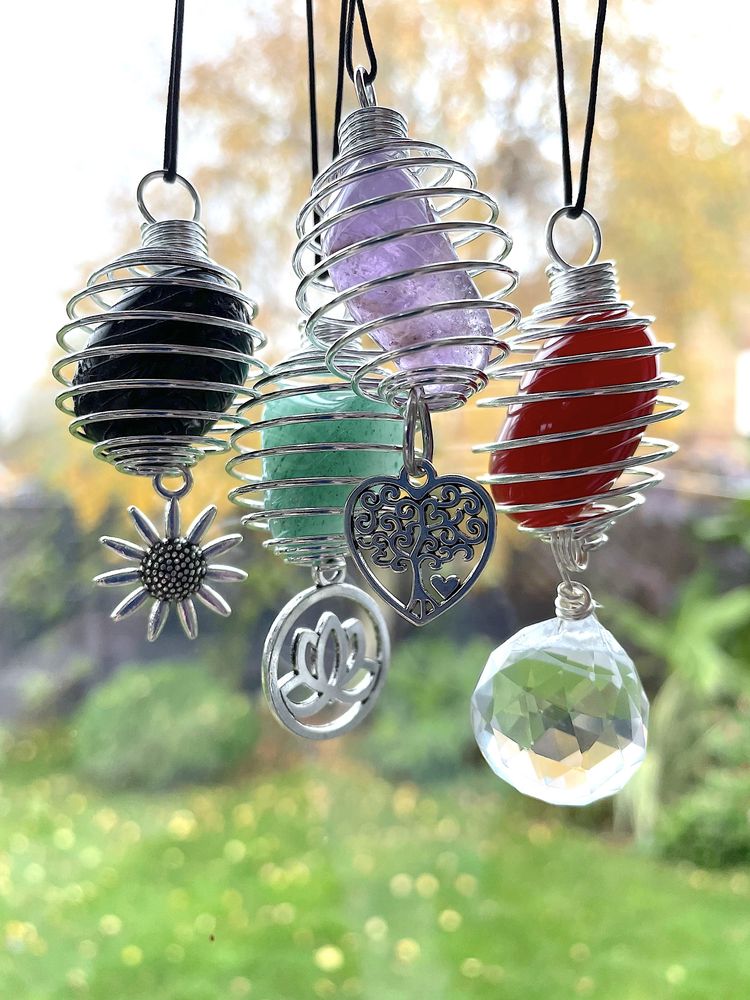 Multiple Crystal car charms hanging with a white background, the holistic hamper crystal shop UK