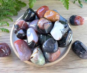 sardonyx tumble stones in oranges, browns and blacks on a dish