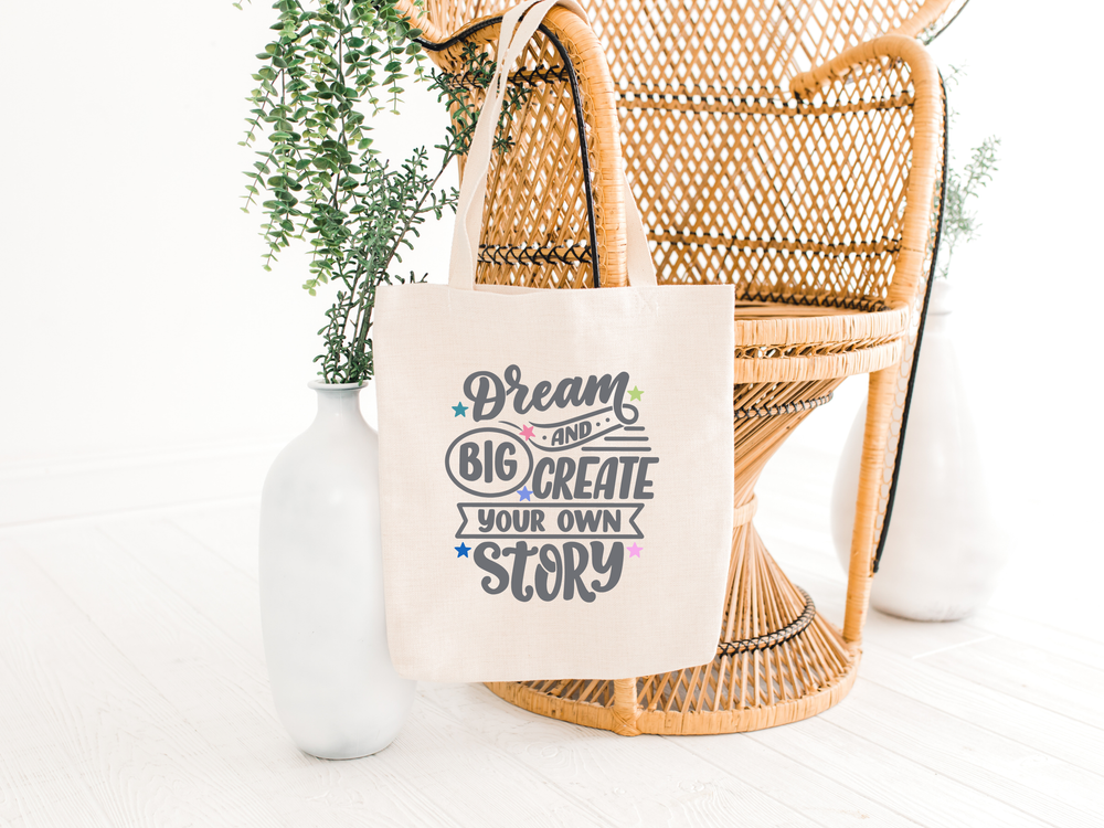 natural cotton tote bag with dream big quote on the front, hanging on a chair, the holistic hamper
