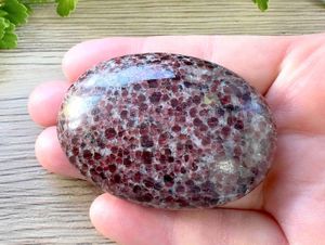 single red garnet palm stone in a hand
