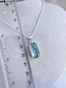 green kyanite rectangular crystal pendant on sterling silver on display bust with optional chain