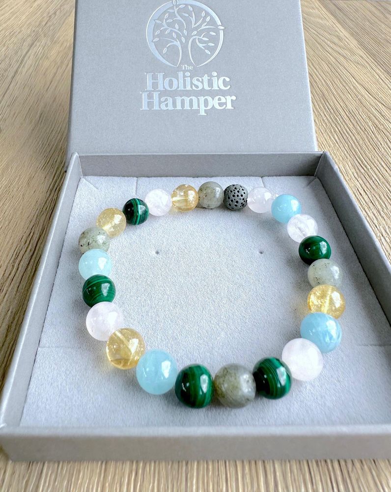 Scorpio zodiac crystal bracelet with lava diffuser bead in pinks, yellows and greens in a box