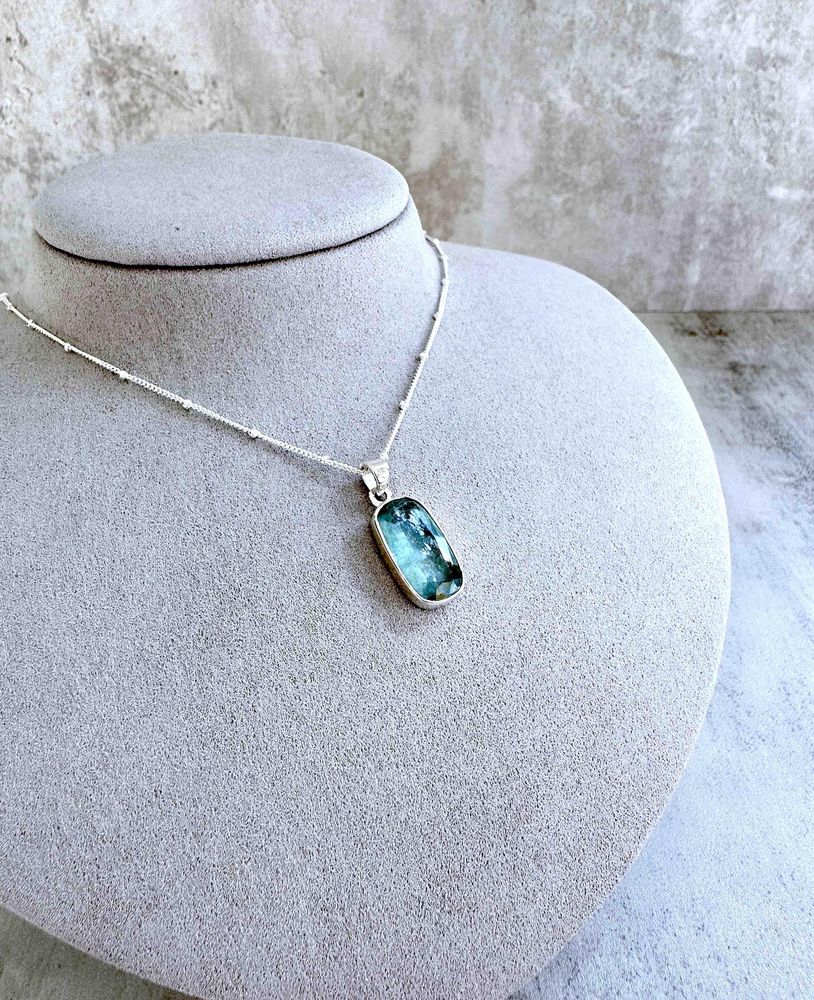 green kyanite rectangular crystal pendant on sterling silver on display bust with optional chain