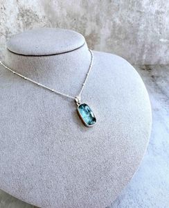 green kyanite rectangular crystal pendant on sterling silver on display bust with optional chain