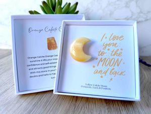 Yellow calcite crystal moon in a gift box with the quote I love you to the moon and back within