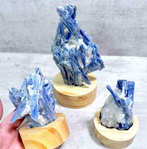 three blue kyanite crystal specimens on wooden display stand