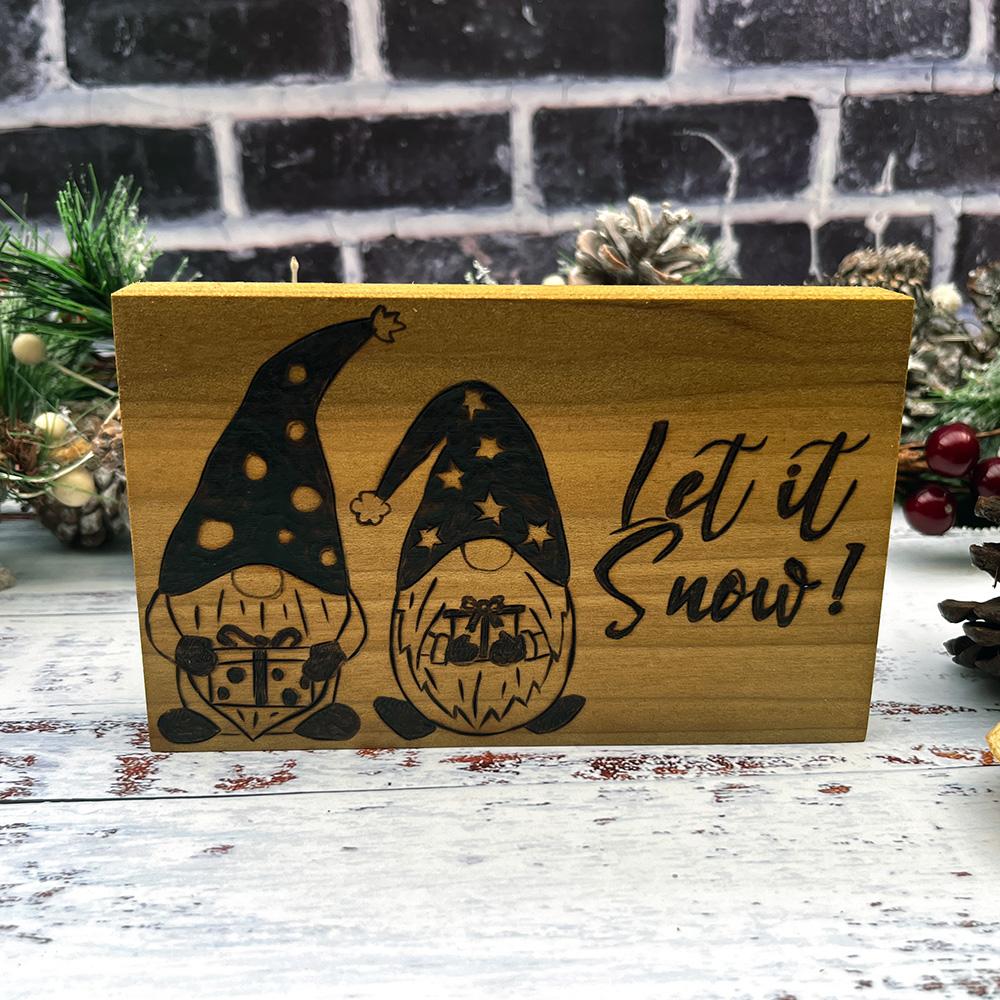 festive gnomes in hats and text let it snow on wooden block