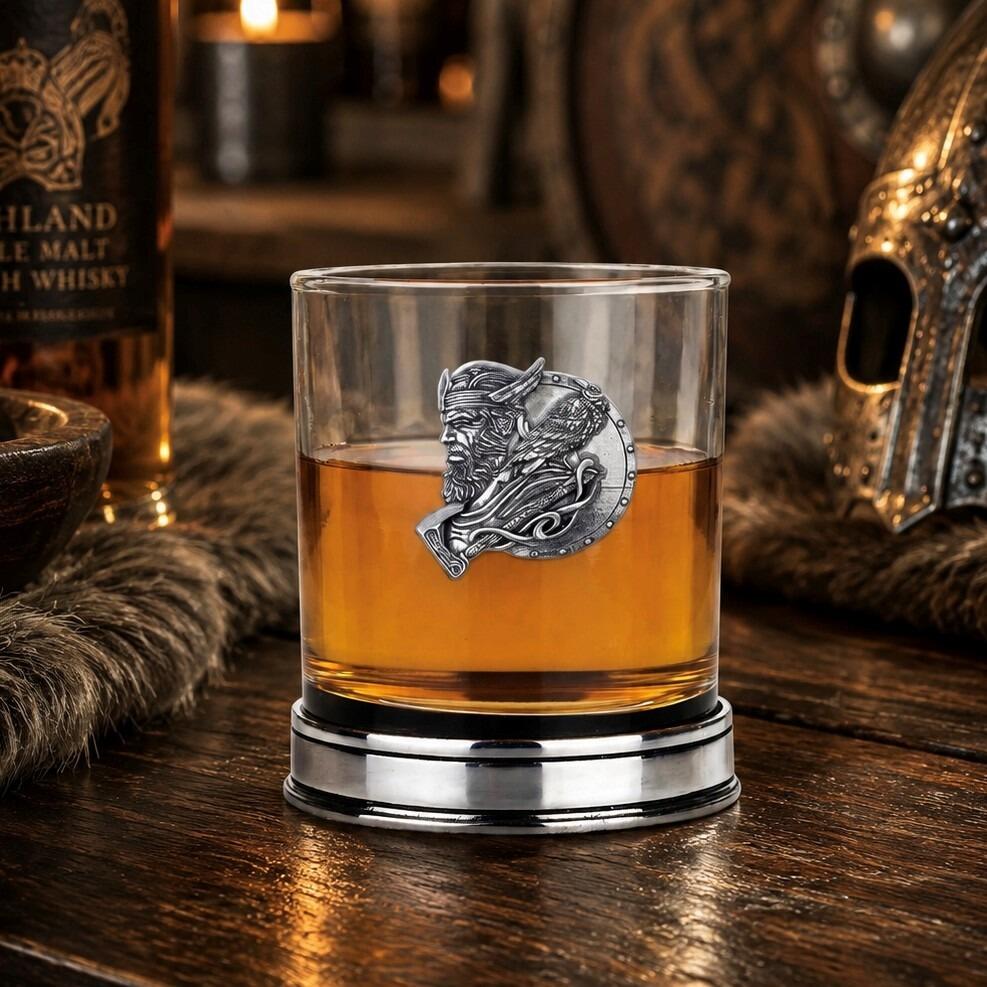 Whisky tumbler with pewter Viking motif and polished base, partially filled with amber liquid