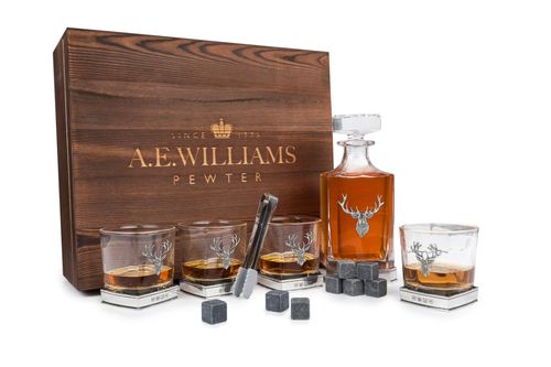 Wooden presentation box displaying decanter and four tumblers with pewter stag motifs, accompanied by whisky stones and tongs