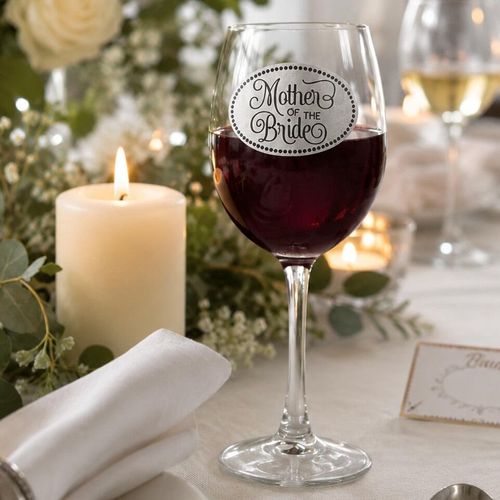 Wine glass with handmade pewter Mother Of The Bride badge filled with red wine