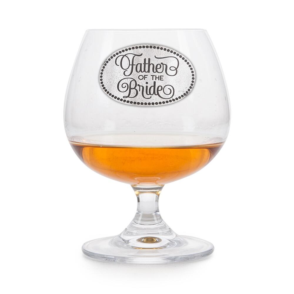 Crystal brandy glass with pewter "Father of the Bride" badge, partially filled with amber liquid