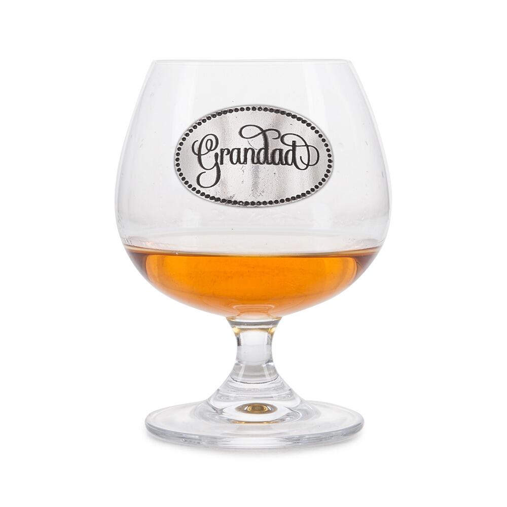 Crystal brandy glass with A E Williams pewter "Grandad" emblem, partially filled with amber liquid