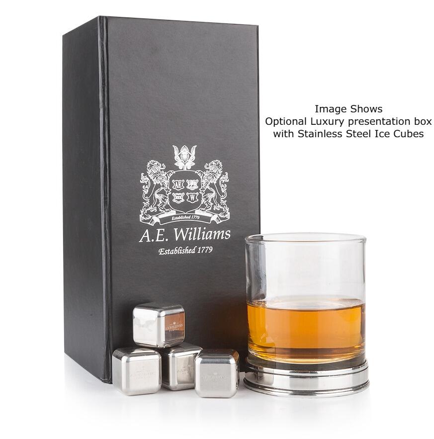 The glass contains an amber-coloured whiskey, and is placed on a round pewter base. The stainless steel ice cubes are cubic in shape and designed to chill the drink without diluting it.
