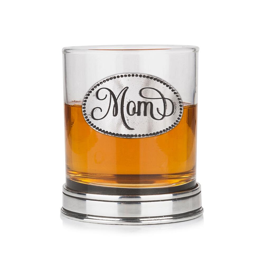 Whisky tumbler with pewter 'Mom' badge and polished base, partially filled with amber liquid